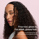Woman with curly hair against a pink background with text about a hair oil product.